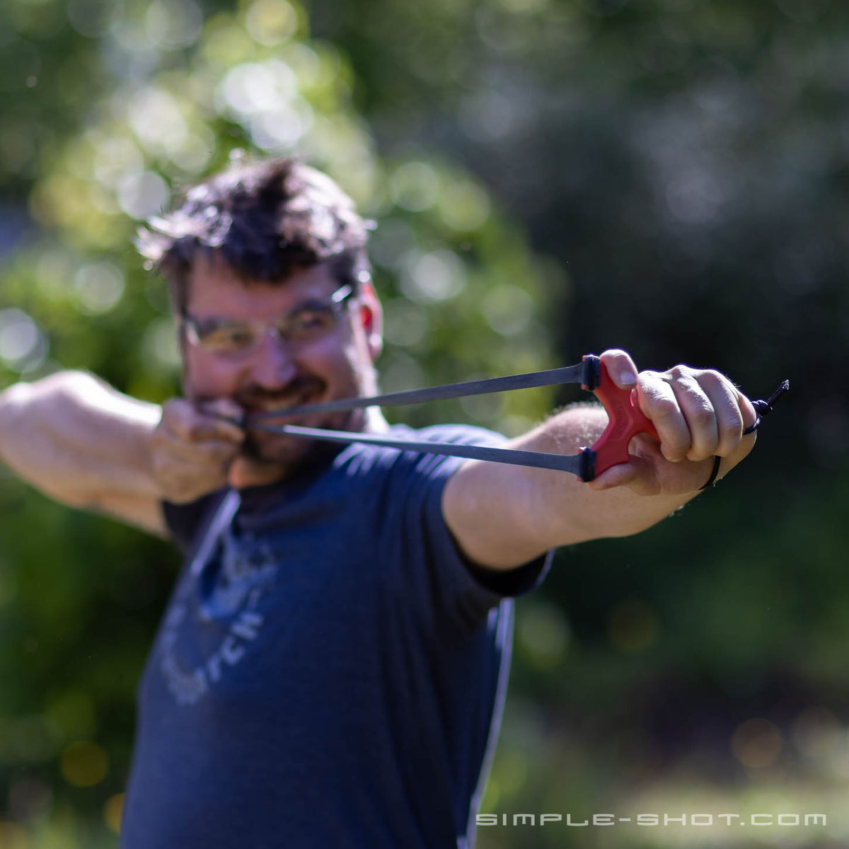 Shooter grinning at full draw with a red Stylus Revolve outdoors