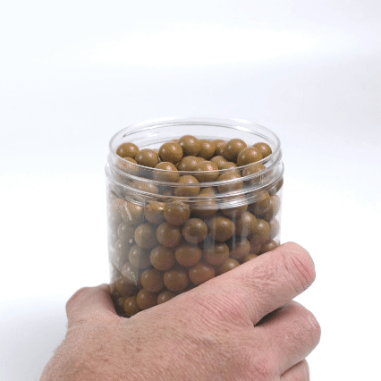 Clay Slingshot Ammo in a clear jar held in one hand
