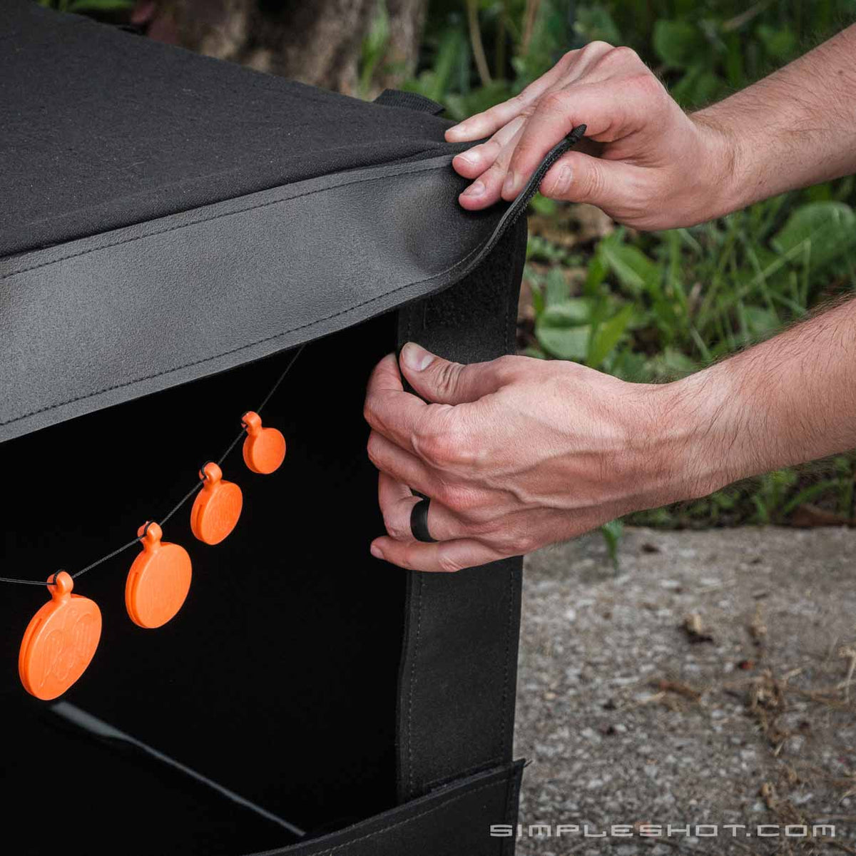 Hands adjusting the cover of the Catchbox for Slingshots
