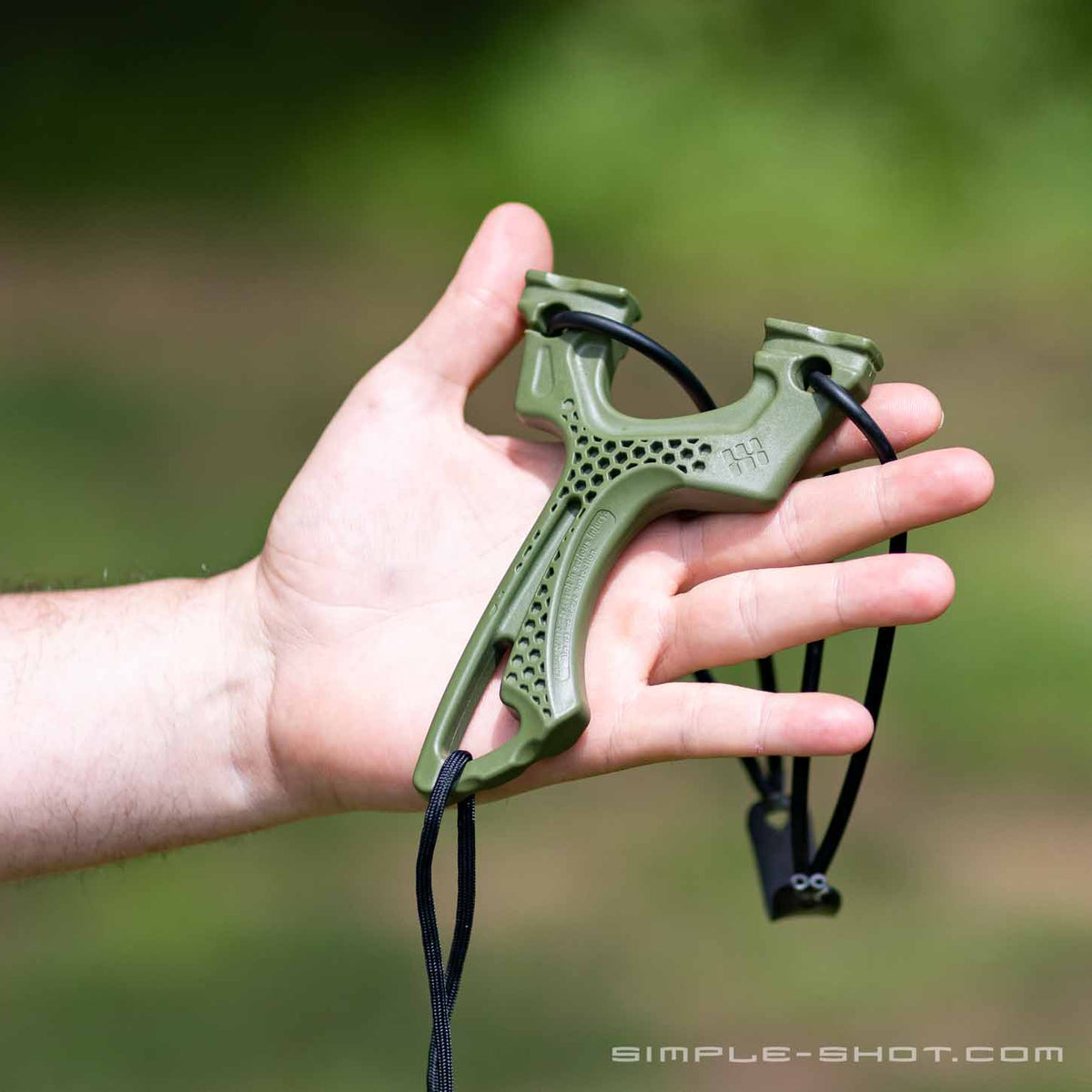 Torque slingshot resting in an open hand outdoors