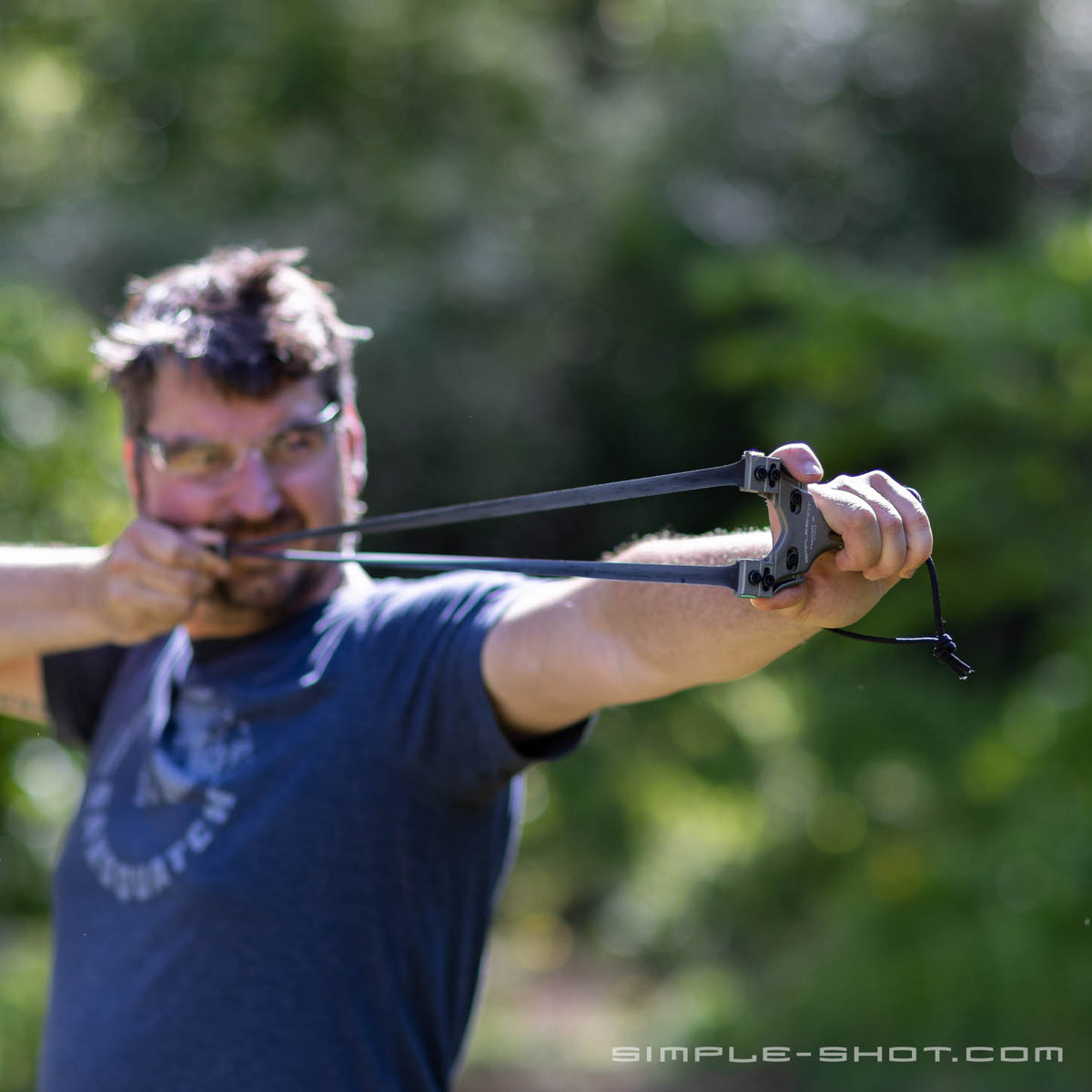Man drawing back the Axiom X slingshot outdoors