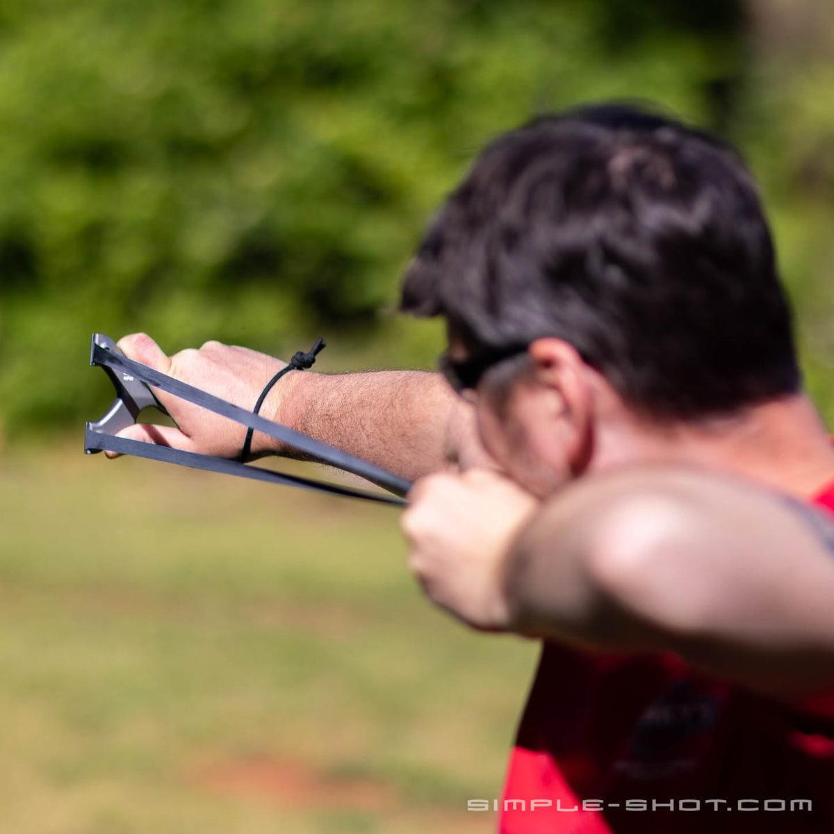 Man drawing back the Stylus Keeper PRO slingshot outdoors