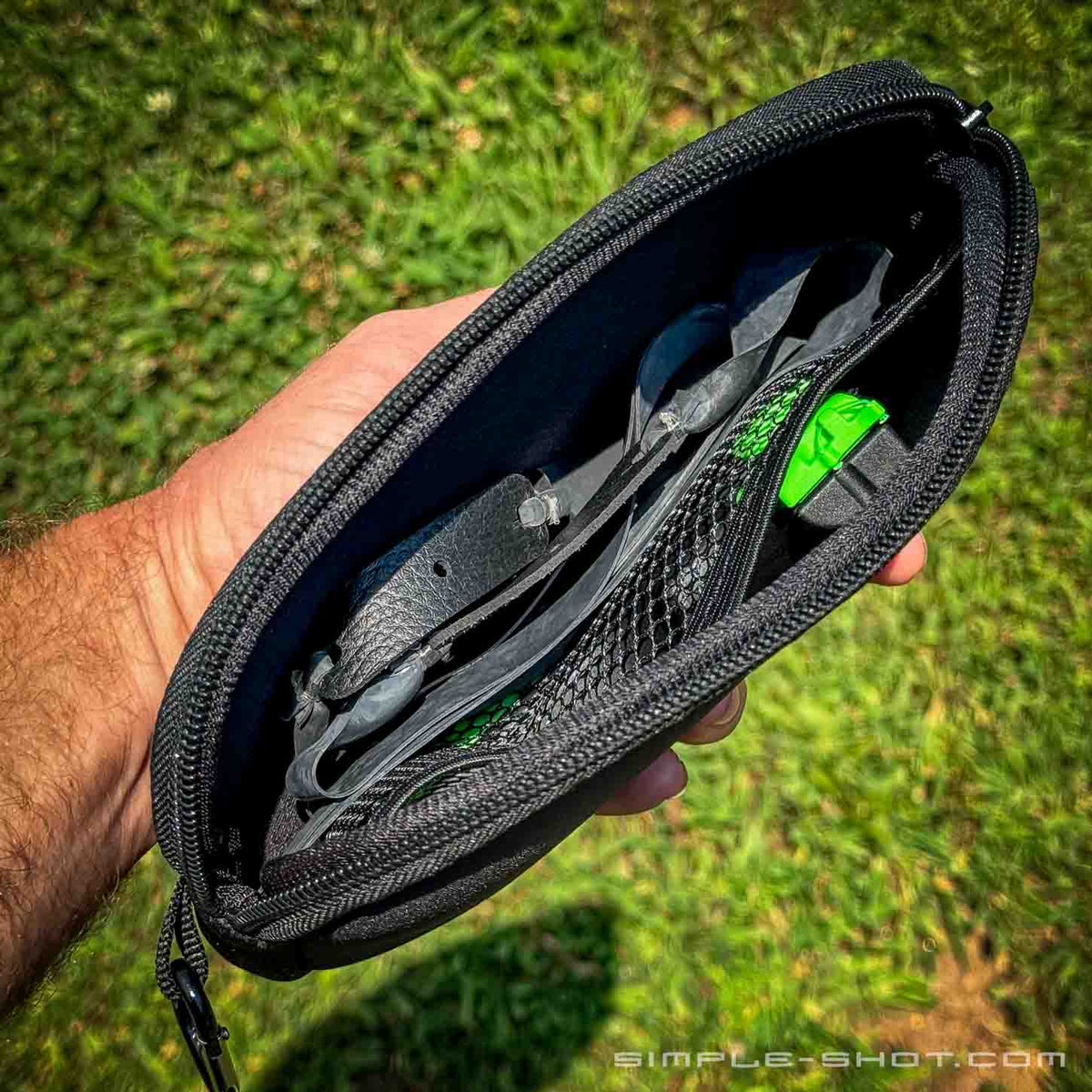 Neoprene Slingshot Pouch held open outdoors with bandsets inside