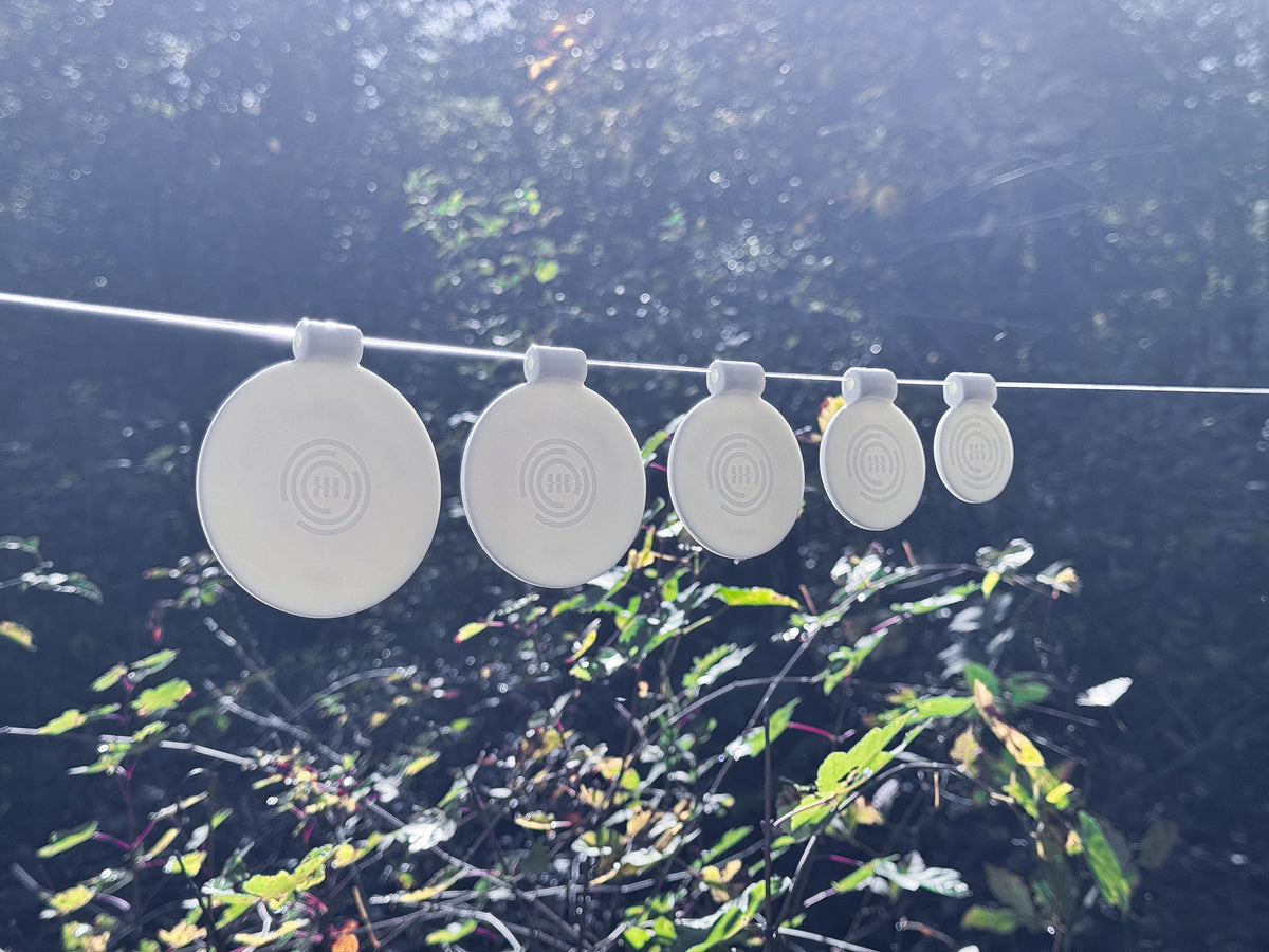 SimpleShot spinner targets hung on a line outdoors in the morning light